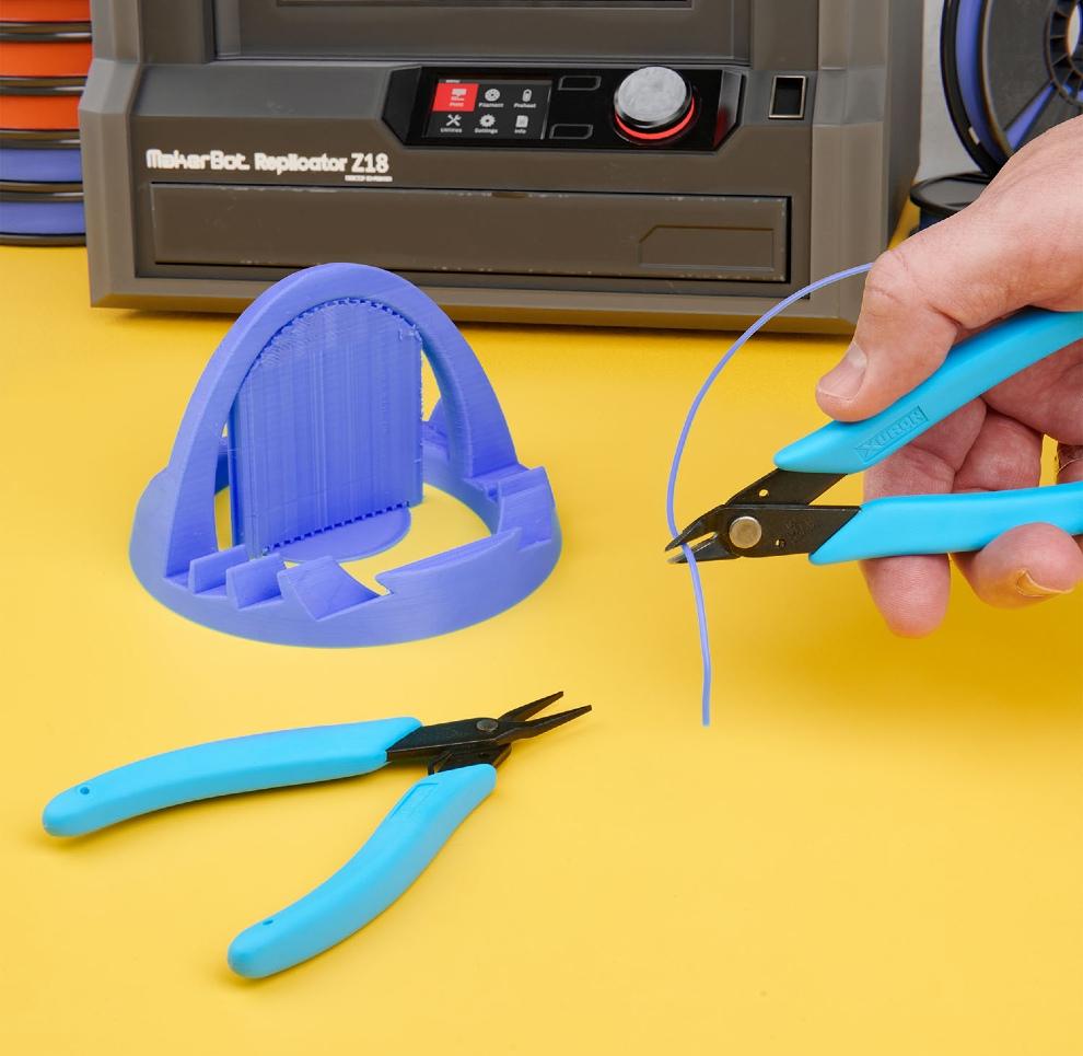 Figure 6 — 6 — Removing support material from a freshly printed part — a post-processing step for the DFCD's printed components. Photo via web search (personal-reference use).