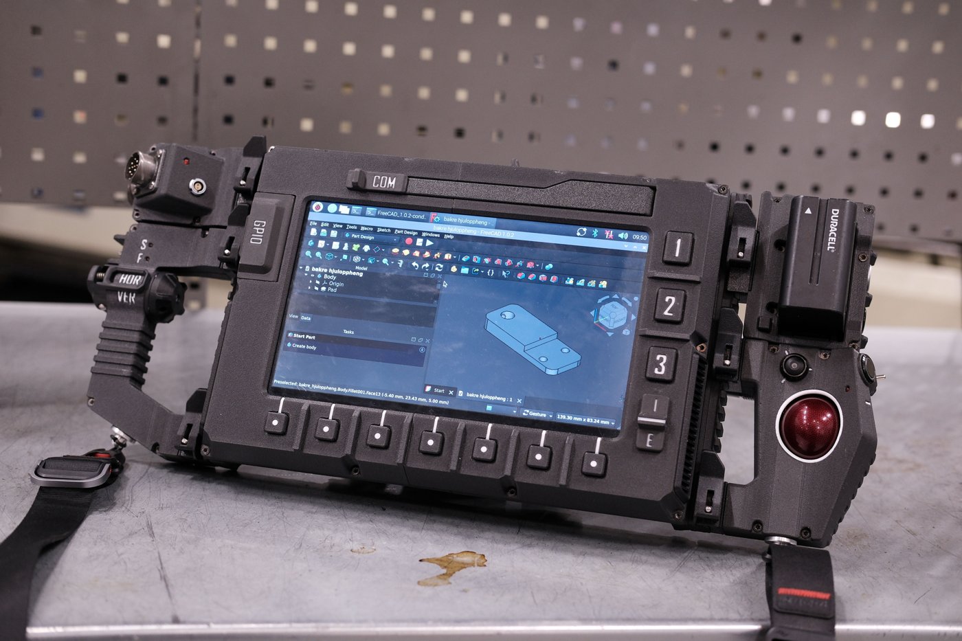 Figure 6 — 6 — The DFCD's assembled control face — the COM and S/F toggles, the HOR/VER scrolling-handle module, the numbered function keys, the tactile-button row, and the red trackball — on the run…